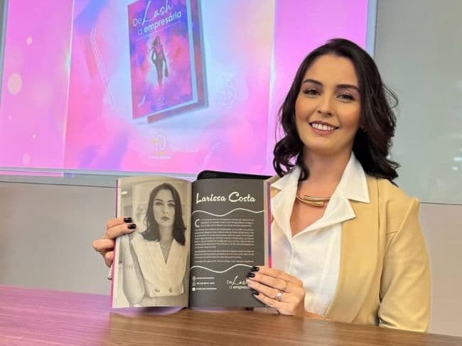 Larissa Costa sorrindo com seu livro sobre emprendedorismo